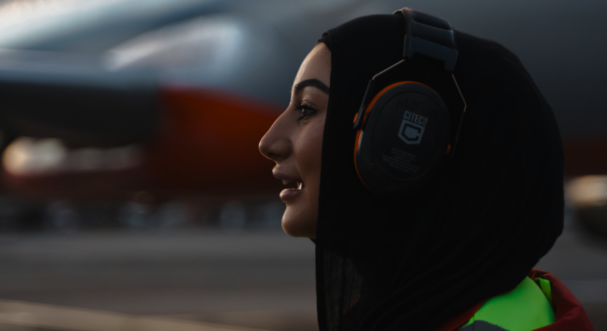 Woman in a hijab wearing ear protection.